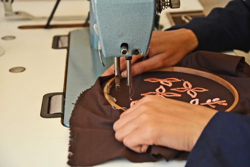 Borduurmachine in de eigen werkplaats van Sweetwood Producties borduurt een bedrijfslogo op textiel